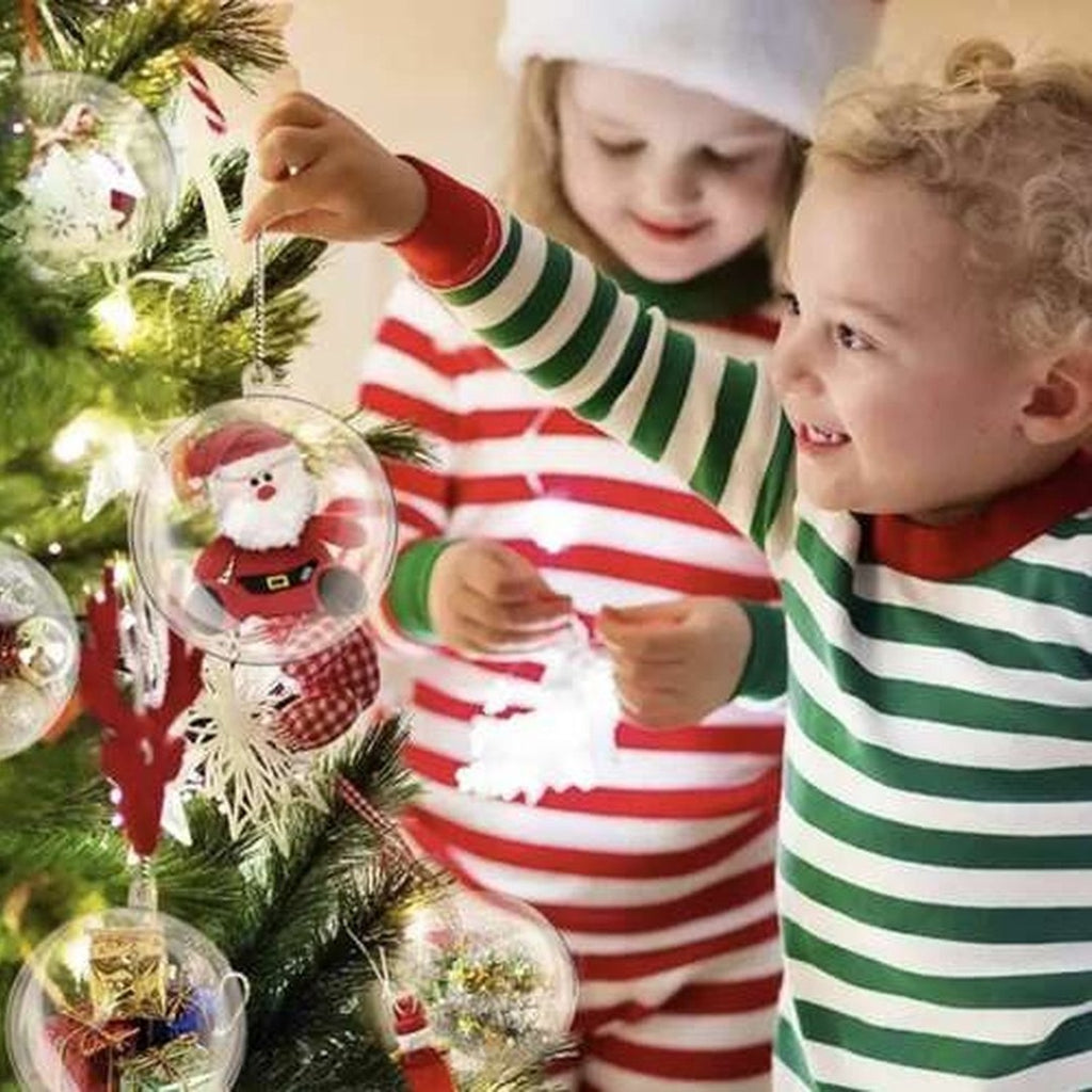 Two children decorating a Christmas tree with 10 x Transparante Kerstballen - 10 cm clear baubles.